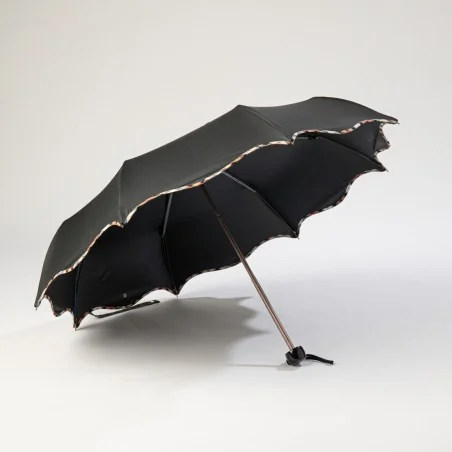 Mini black umbrella with wave pattern, open from the front